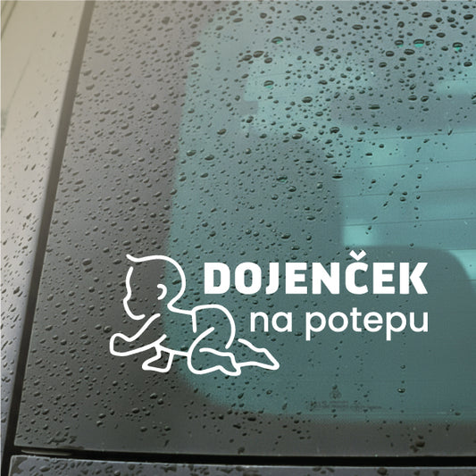Avto nalepka z napisom 'Dojenček v avtu' v beli barvi na zadnjem steklu od avtomobila